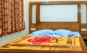 una cama con una pintura de rosas rojas en ella en WILLOW HILL LEISURE HOME, en Munnar