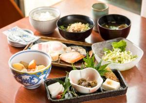 a wooden table with bowls of food on it at APA Hotel Kanazawa Nomachi in Kanazawa