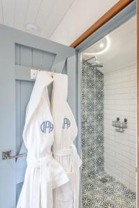 a bathroom with white towels hanging on a door at Daisy Park Shepherds Hut in Looe