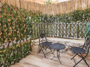 deux chaises et une table devant un mur de plantes dans l'établissement בחיק החרמון, à Majdal Shams