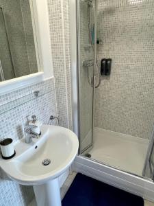 a bathroom with a sink and a shower at Family Friendly Maritime Apartment in Swansea