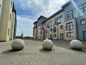 tres bolas están sentadas en el medio de un edificio en Family Friendly Maritime Apartment, en Swansea