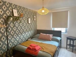 a bedroom with a bed and a wall at Family Friendly Maritime Apartment in Swansea
