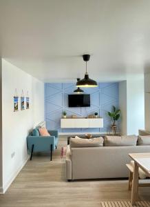 a living room with a couch and a tv at Family Friendly Maritime Apartment in Swansea