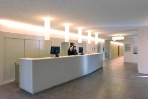 a woman standing at a counter in an office at St. Moritz Youth Hostel in St. Moritz