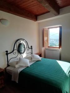 - une chambre avec un lit vert et une fenêtre dans l'établissement Casetta dei sibillini, à Fiastra