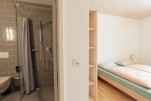 
a bathroom with a shower and a bed at St. Moritz Youth Hostel in St. Moritz
