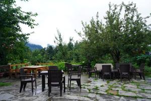 a group of tables and chairs in a garden at Jungle by sturmfrei Manali in Manāli
