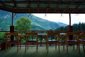 a table and chairs with a view of a mountain at Jungle by sturmfrei Manali in Manāli