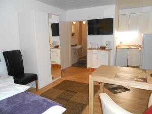 a living room with a table and a kitchen at Warum ins Hotel in Neckarsulm