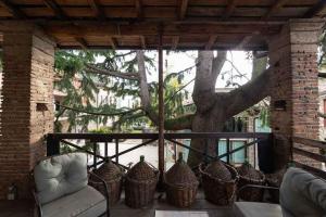 een veranda met stoelen en een boom op de achtergrond bij Corte del Cedro in Provaglio d'Iseo