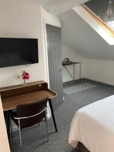 a hotel room with a desk and a bed and a tv at Langley House Hotel in Blackpool