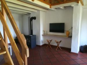 a living room with a flat screen tv and a stove at Charmant Mas tout équipé en pleine nature catalane in Cases-de-Pène
