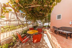 a patio with tables and chairs and plants at Family blue apartman Montenegro in Baošići