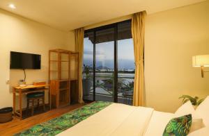 Pokój hotelowy z łóżkiem, biurkiem i oknem w obiekcie Eco Tree O'tel w Labuan Bajo