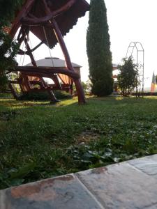 a park with a swing set in the grass at Restaurant Vi La Maria in Baia de Fier