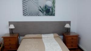 a bedroom with a bed with two dressers and two lamps at Pension Santa Rita in Santiago de Compostela