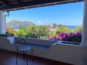 une chaise assise sur un balcon avec vue dans l'établissement Hotel Villa Diana, à Lipari