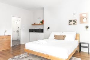 Un dormitorio blanco con una gran cama blanca. en מתחם אירוח אוליאה - Olea, en Rosh Pina
