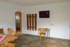 a dining room with a table and chairs and a tv on the wall at Grossummerstall in Mittersill