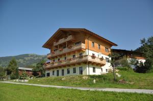 a large building with a balcony on a hill at Grossummerstall in Mittersill