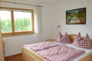 a bedroom with a bed with pillows and a window at Grossummerstall in Mittersill