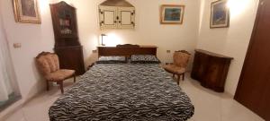 una camera da letto con un grande letto con due sedie di La Casa di Francesco a Saline Joniche