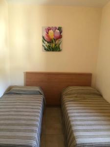 2 letti in una camera con un dipinto sul muro di Hostels Euro Mediterraneo a Rossano