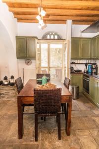 kuchnia z drewnianym stołem i krzesłami w obiekcie Tinos Cycladic house w mieście Kariá