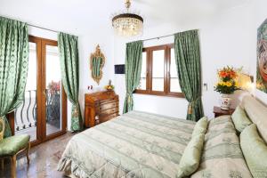 a bedroom with a bed and a couch and windows at Luxury Villa Taormina city center, terrace with views in Taormina