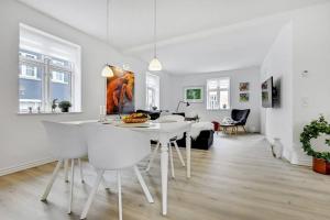 a kitchen and living room with a white table and chairs at *****elegant feriebolig i hjertet af Kerteminde in Kerteminde