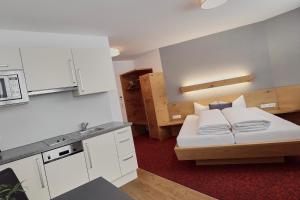 a small room with a bed and a kitchen at Hotel Garni & Aparthotel COLLINA in Ischgl