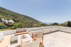 a view from the balcony of a villa with a table and chairs at Tinos Cycladic house in Kariá