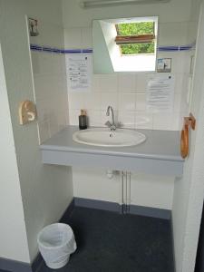 a bathroom with a sink and a window at Auberge de Jeunesse HI Pontivy in Pontivy