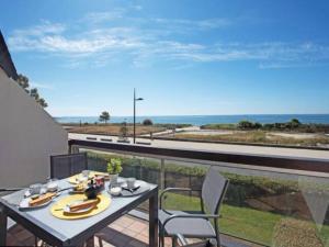 d'une table et de chaises sur un balcon avec vue sur l'océan. dans l'établissement Carnac : Appt 4 p. Face mer vue exceptionnelle, à Carnac