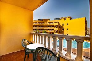 エル・メダノにあるAlquilaencanarias-Medano Atalaya, terrace & poolの建物の景色を望むバルコニー(テーブル、椅子付)