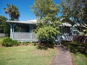 a house with a white porch and a fence at Where the River Runs in Tea Gardens