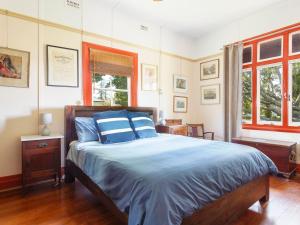 a bedroom with a large bed with blue pillows at Where the River Runs in Tea Gardens