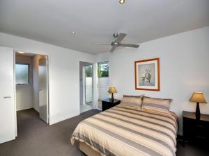 a bedroom with a bed and a ceiling fan at Stunning Holiday Townhouse in Tea Gardens