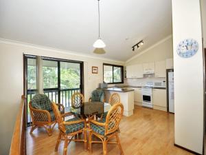 a kitchen and dining room with a table and chairs at Pet Friendly on Pelican Close to Myall River in Hawks Nest