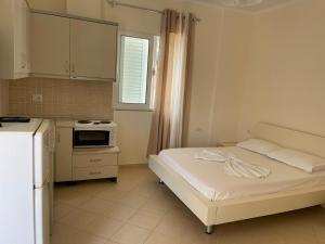 a small kitchen with a bed in a room at Sunset Apartments Berdenesh Sarandë in Sarandë