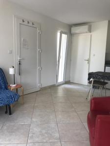 a living room with a red couch and a door at studio neuf climatisé in Les Fumades-Les Bains