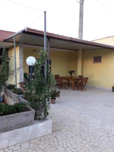 eine Terrasse mit einem Tisch, Stühlen und Pflanzen in der Unterkunft VILLETTA SALENTO S.M.DI LEUCA 6 POSTI LETTO in Corsano