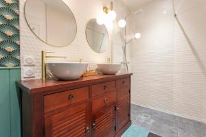 a bathroom with two sinks and two mirrors at La Bellevue Bréville - B&B in Bréville-sur-Mer