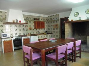 cocina con mesa de madera y sillas rosas en Villa Antonia, en Sa Coma