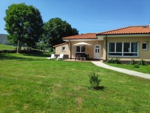 a house with a grass yard and a patio at El Cerrón in Llanes