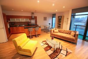 een woonkamer met een gele bank en een tafel bij Hydro Apartments in Glasgow