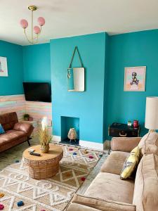 uma sala de estar com paredes azuis e um sofá em Seaside Sundae Suite em Lytham St Annes