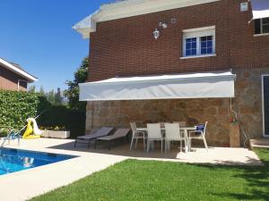 a patio with a table and chairs next to a pool at Casa Bellavista Becerril in Becerril de la Sierra