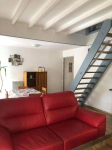 a red couch in a living room with a staircase at les magnolias in Colmar